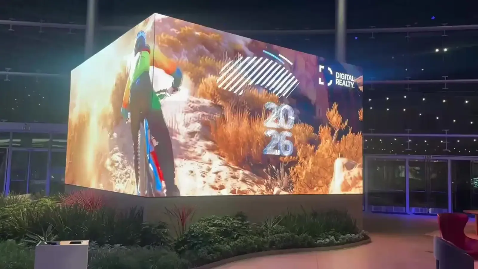 A large illuminated cube display showing Digital Realty imagery in an event venue.