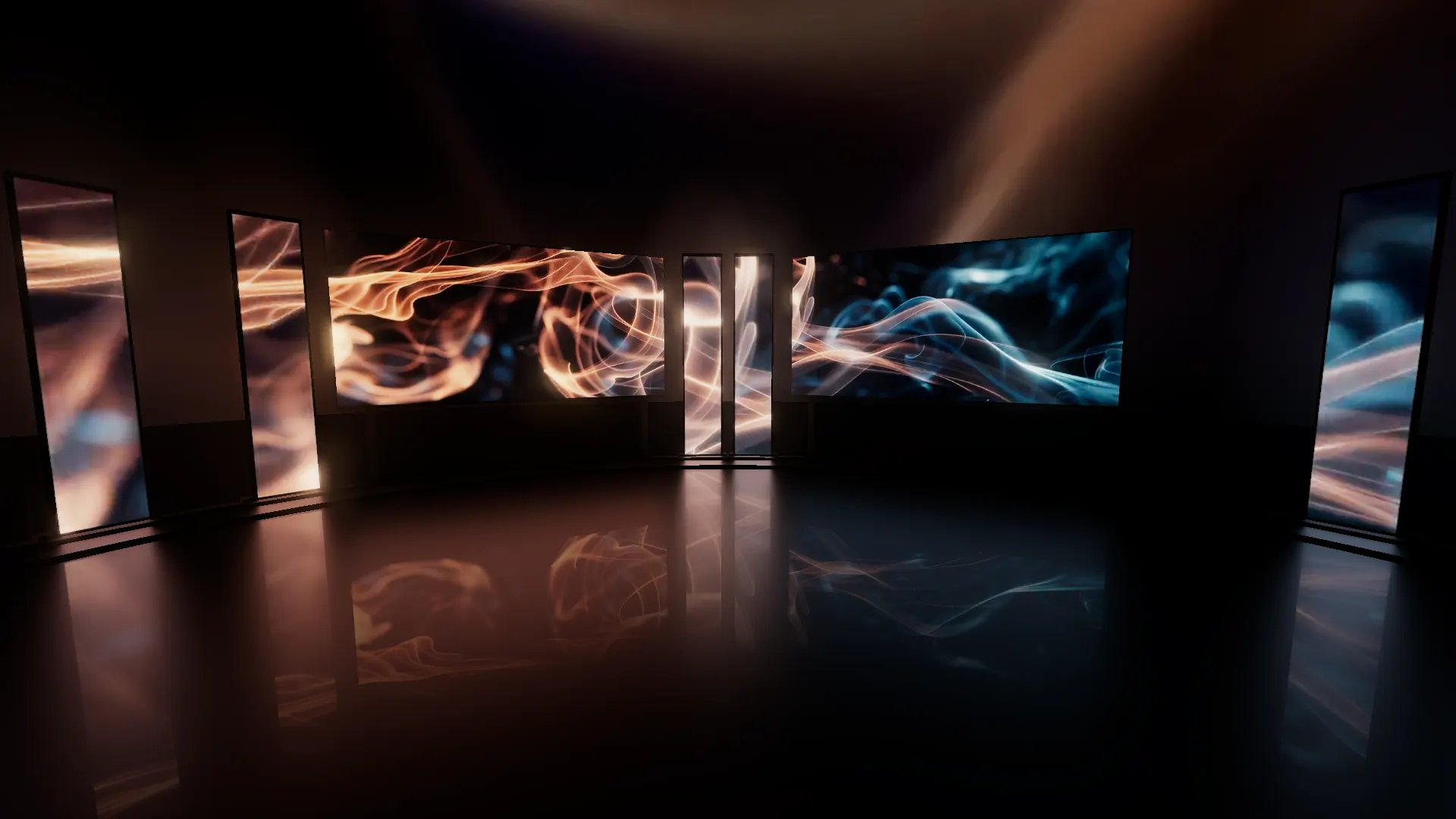 The event room seen from its centre: two main screens in front and LED columns curving round both sides, all showing orange and blue visuals, in front of a soft wall of the show's fire and smoke.